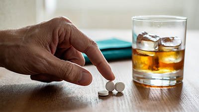 Препарат со стаканом алкоголя на столе